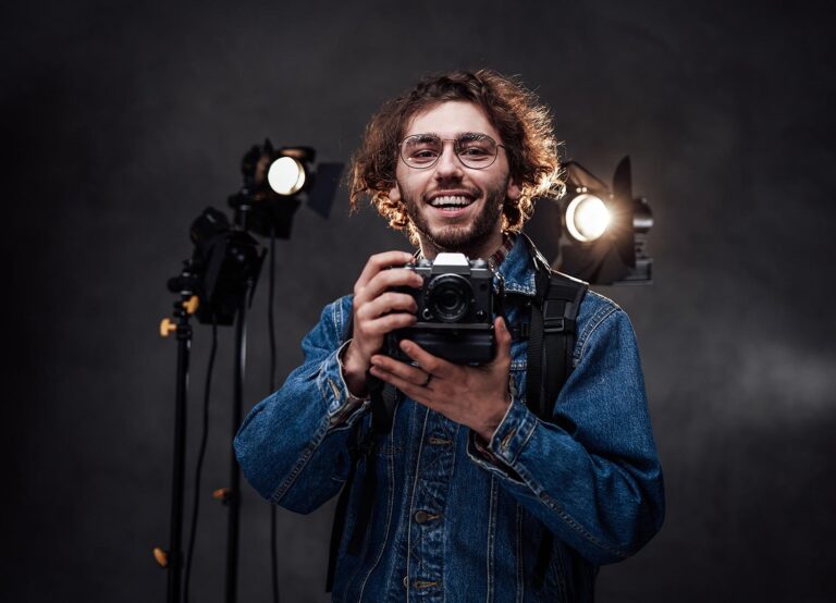 About Young Photographer Holds A Camera Studio Portrait Resize 768x554